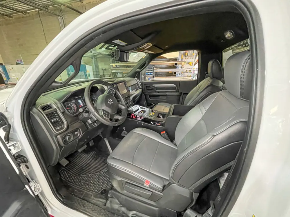 Exterior view of small fire truck showing cab, body compartments, and wheel/tire area.